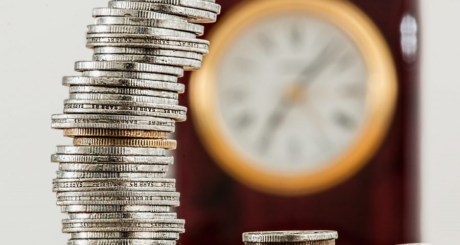 Stack of coins with clock in background