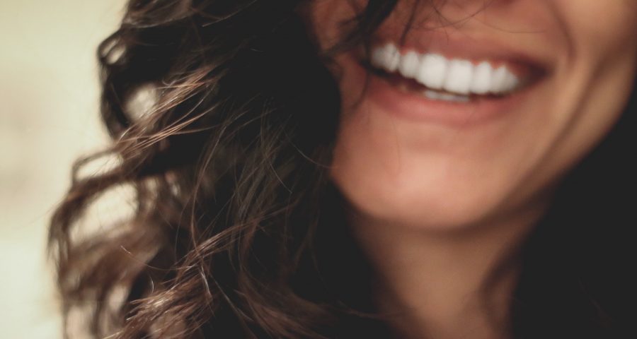 Close up photo of a women's smile and dark hair